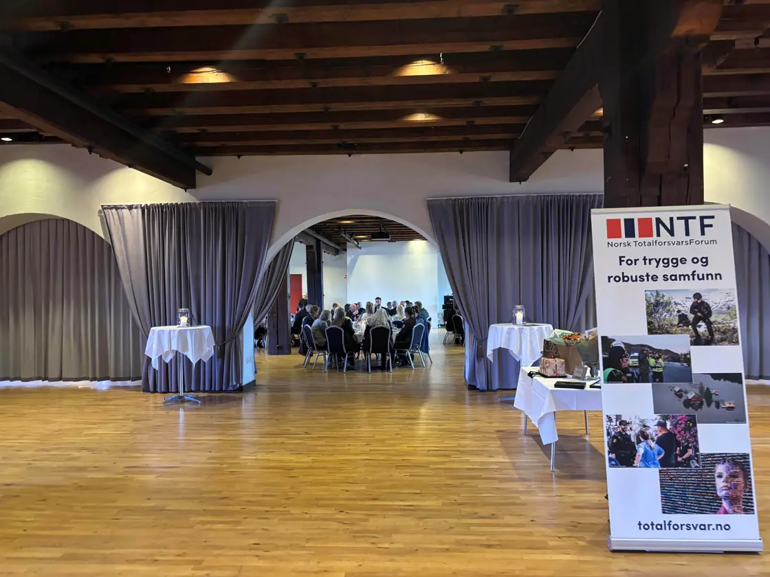 En sal med mennesker sittende til bords