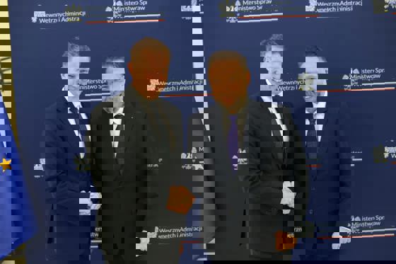 To menn hilser på hverandre med håndtrykk