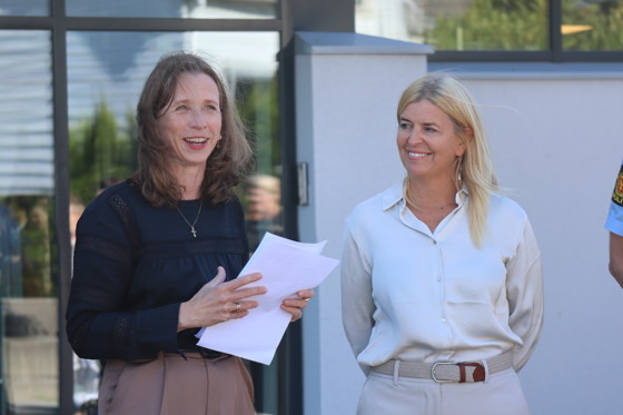 To smilende kvinner, hvorav den ene ser på den andre