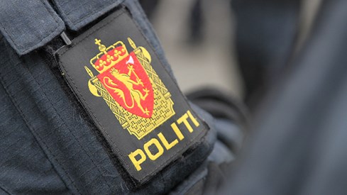 Nærbilde av politiemblem på armen til en politi i uniform