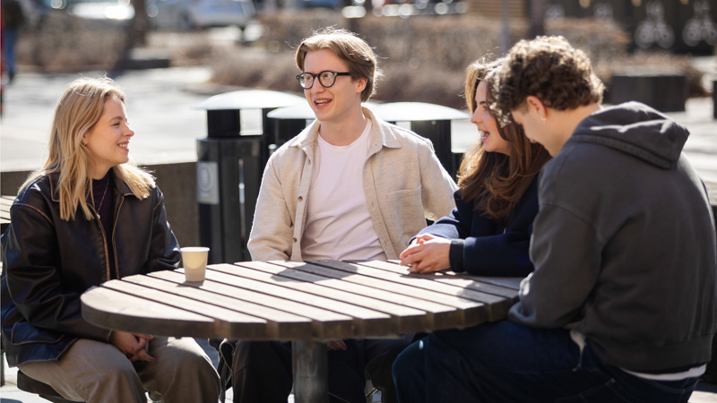 Tre studenter sitter utenfor Universitetet i Oslo