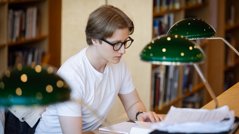 Student sitter på lesesal