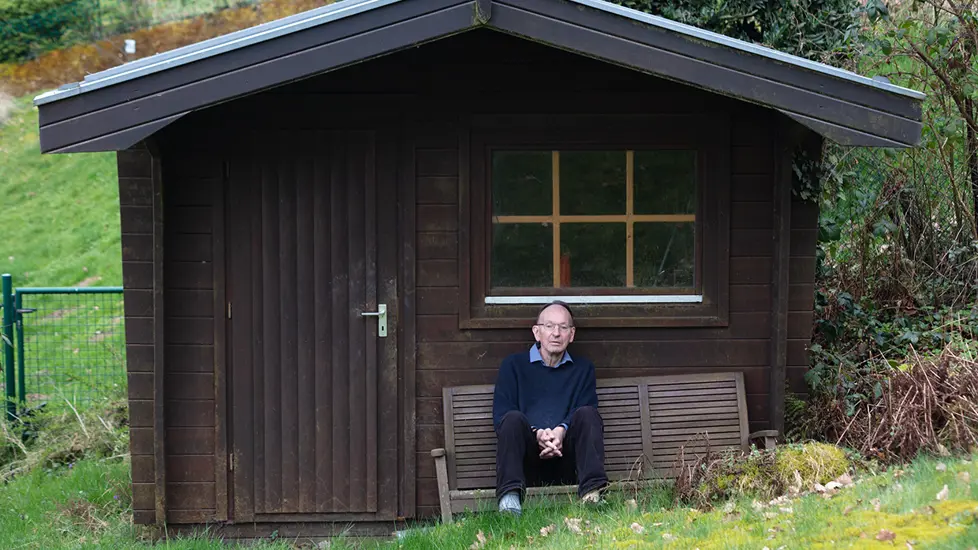 Abelprisvinner Gerd Faltings sittende foran en hytte