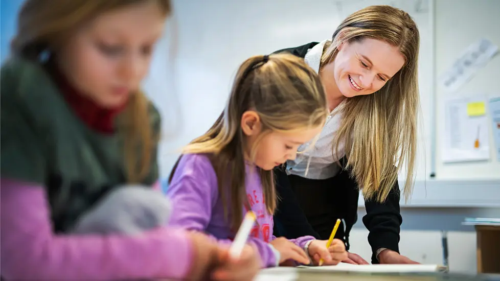 En lærer hjelper elev i klasserommet