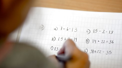 Bilde av et barn som løser regnestykker