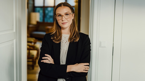 Kvinne står i døråpningen med armene i kors