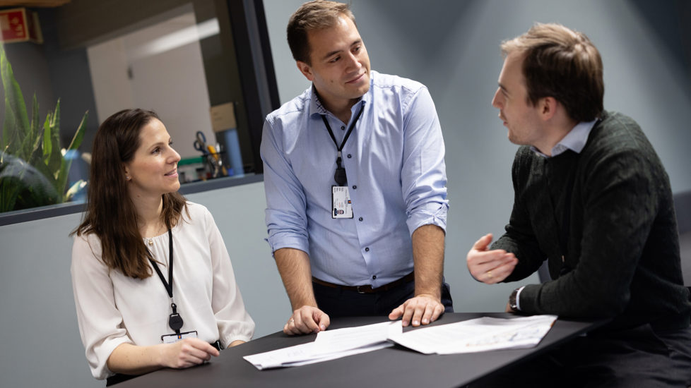 Tre personer samlet rundt et bord