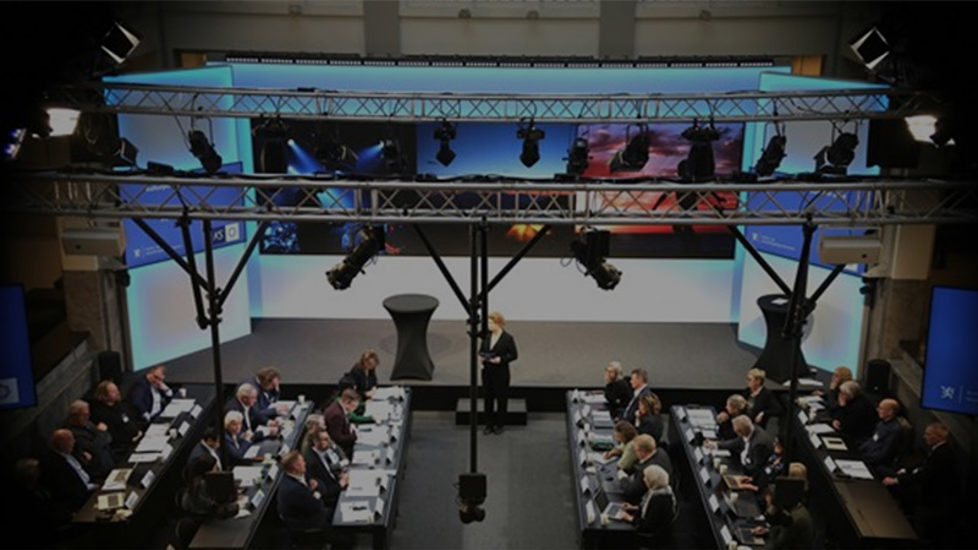 Bilde tatt ovenfra som viser folk i salen under toppmøtet