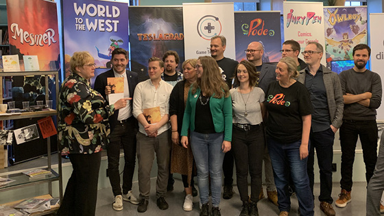 Gruppebilde fra presentasjonen av dataspillstrategien. Gruppen står foran plakater med ulike spillselskaper.