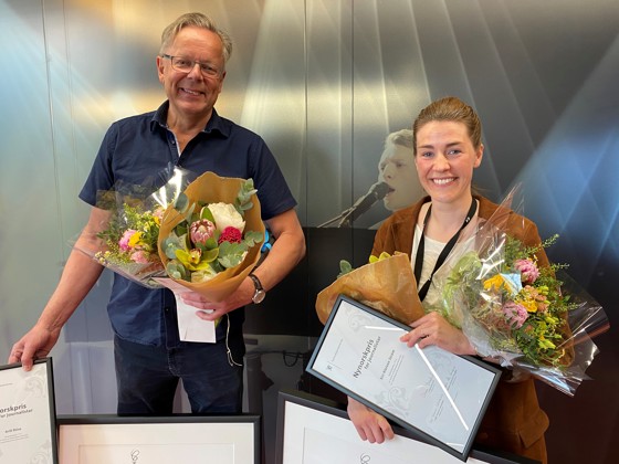 Journalistane Siri Kleiven Strøm og Arill Riise i TV 2 står saman med blomer, diplom og kunstverk. Foto: Magni Øvrebotten/NRK