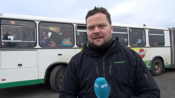 Roger Sevrin Bruland foran ein buss med flyktningar.