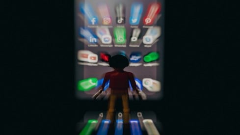Playmobil-figur står foran en mobil med ulike ikoner for sosiale medier
