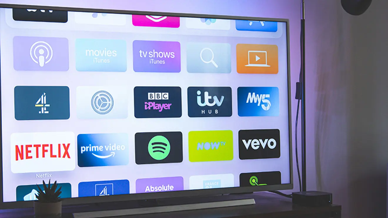 Nærbilde av TV-skjerm med meny med ulike strømmetjenester.