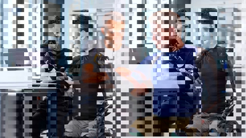 Illustrasjonsbilde av mann i rullestol som får tilpasset armproteser.