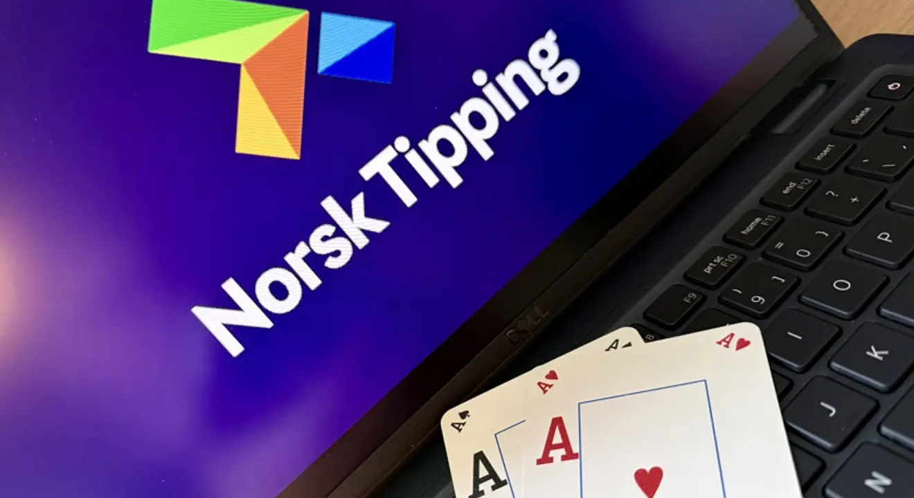 Illustrasjonsbilde: To Ess ligger på tastaturet til n bærbar PC. Norsk Tippings logo er på skjermen.tstokk foran