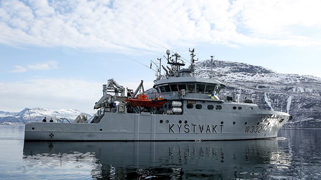 Kystvaktskipet "Heimdal" fotografert frå sida på stille hav.