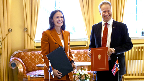 To personer viser fram en signert avtale