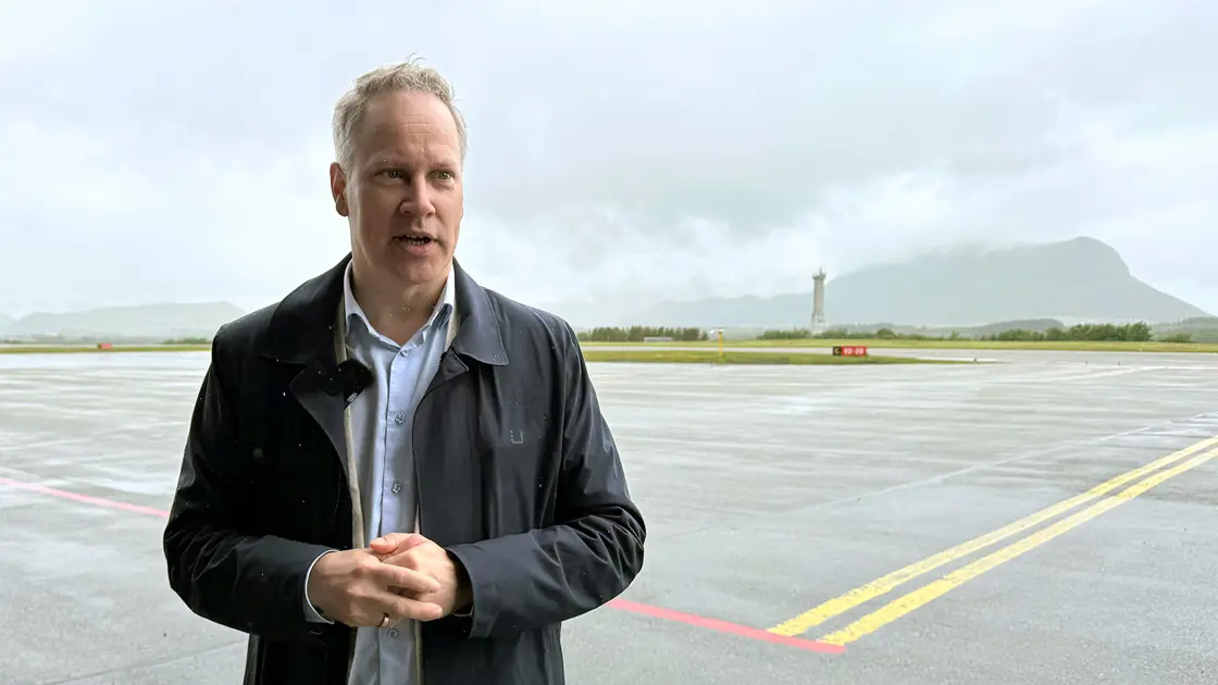 En person står på en rullebane. I bakgrunnen et flytårn.