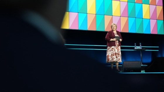 Statsminister Erna Solberg står på scenen i Oslo Spektrum for å tale på NHOs årskonferanse.
