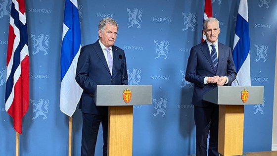 Finlands president Sauli Niinistö og statsminister Jonas Gahr Støre står foran en blå vegg med riksløver og snakker med pressen.