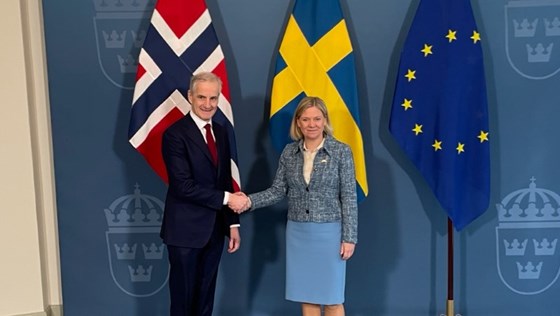 Sveriges statsminister Magdalena Andersson og Norges statsminister Jonas Gahr Støre tar hverandre i hendene.