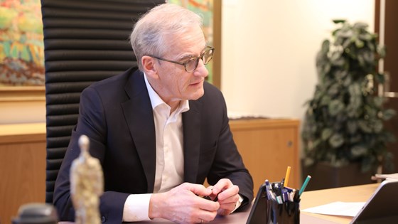 Statsminister Jonas Gahr Støre sitter på kontorstolen på kontoret sitt og snakker med Moldovas statsminister på telefonen.