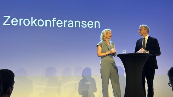 ZERO-leder Sigrun G. Aasland og statsminister Jonas Gahr Støre står på en scene med talerstol
