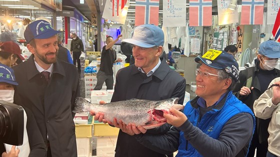 Fra japansk fiskemarked. Statsministeren holder opp en norsk fisk.