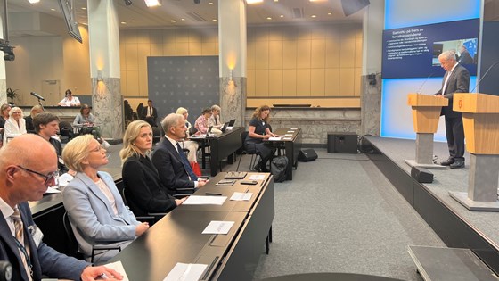 Utvalgsleder Øystein Olsen står på scenen i Marmorhallen og presenterer utvalgets rapport. Står ved talerstol.