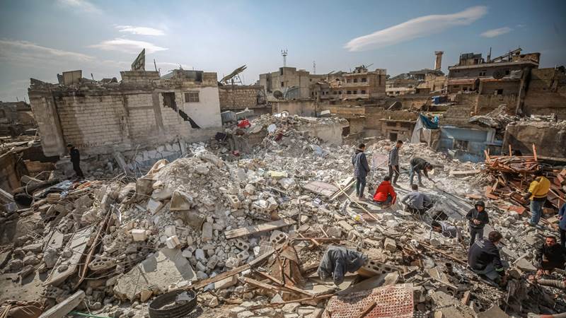 Bilde fra ruiner etter jorskjelvet i Tyrkia. Innbyggere leter i betongruiner.