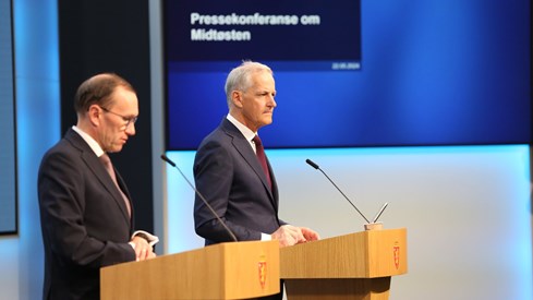 Utenriksminister Espen Barth Eide og statsminister Jonas Gahr Støre står på scenen i Marmorhallen. Blått bakteppe.