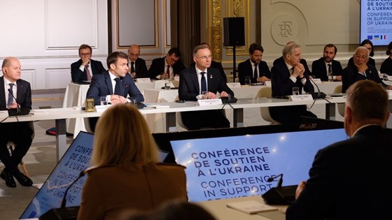 Bilde fra konferansesalen, hvor man ser en del av deltakerne, blant annet Scholz, Macron og Støre.