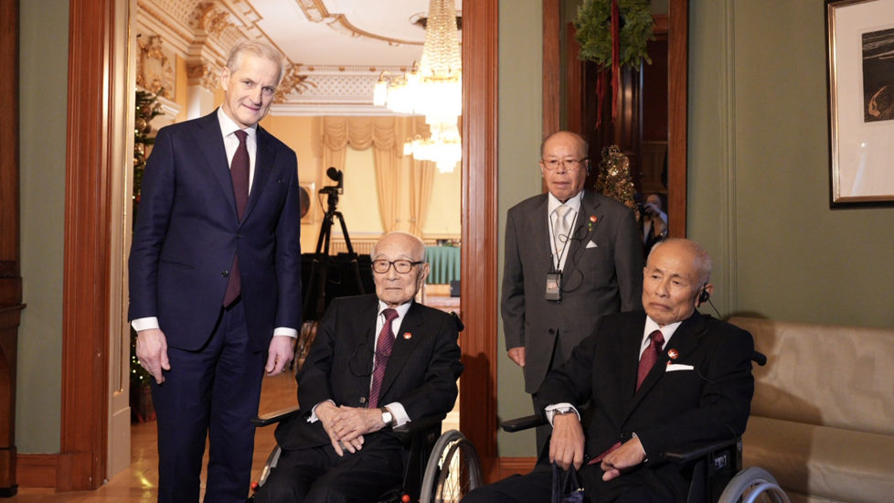 Statsministeren står ved siden av de tre representantene for vinneren av Nobels fredspris 2024.