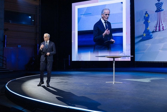 Støre står på scenen i Bergen. Gestikulerer mens han holder talen sin.