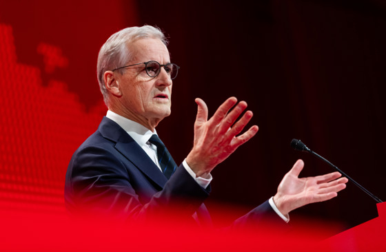 Statsminister Jonas Gahr Støre står bak en talerstol og gestikulerer med hendene.