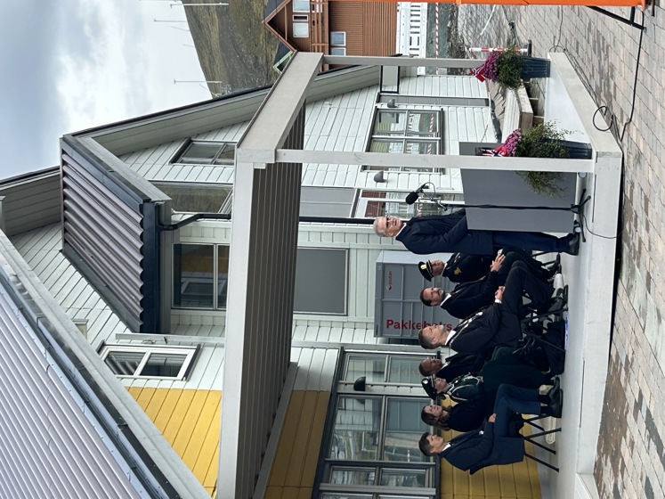 Statsministeren står bak en talerstol i Longyearbyen.