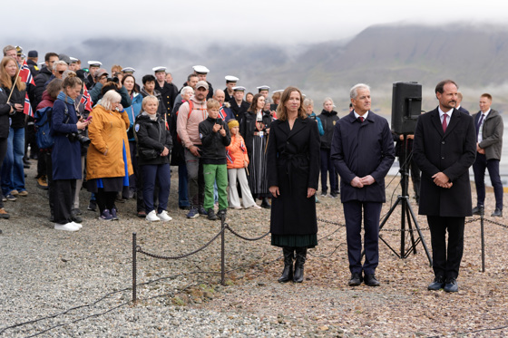 En folkemengde står til venstre for justisministeren, statsministeren og Kronprinsen.
