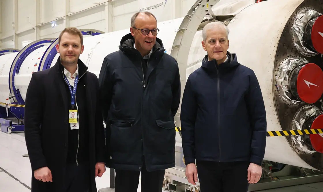 Forbundskansleren og statsministeren får en omvisning. Rakett i bakgrunnen.