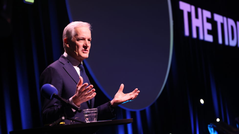 Statsministeren på scenen i Tromsø. Gestikulerer mens han prater.