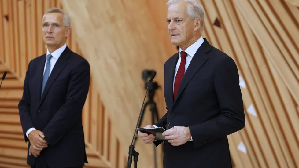 Stoltenberg og Støre står bak hver sin mikrofon i foajeen i A-blokka i regjeringskvartalet.