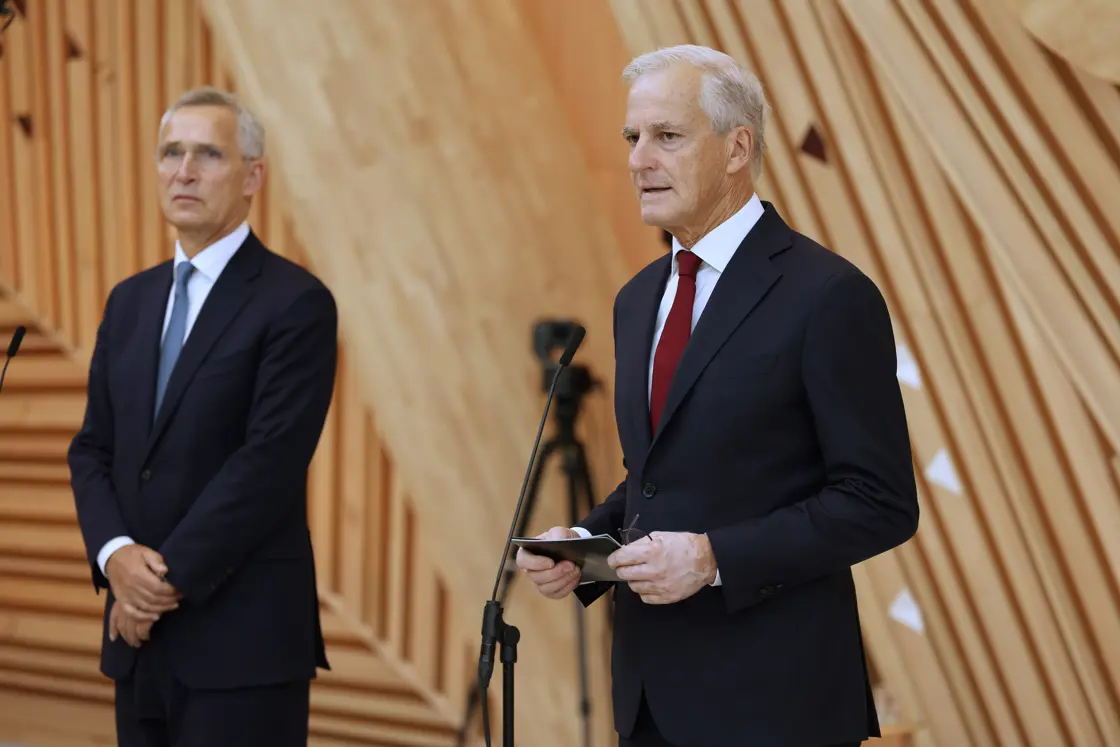 Stoltenberg og Støre står bak hver sin mikrofon i foajeen i A-blokka i regjeringskvartalet.