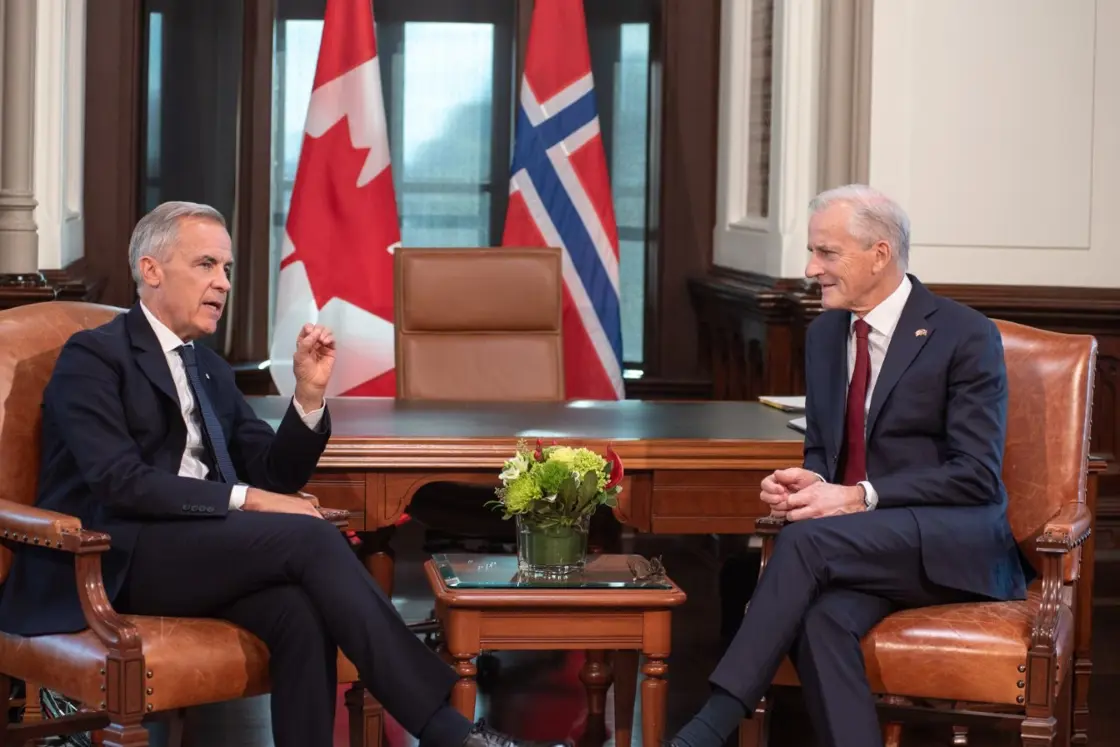 Carney and Støre sitting in chairs.