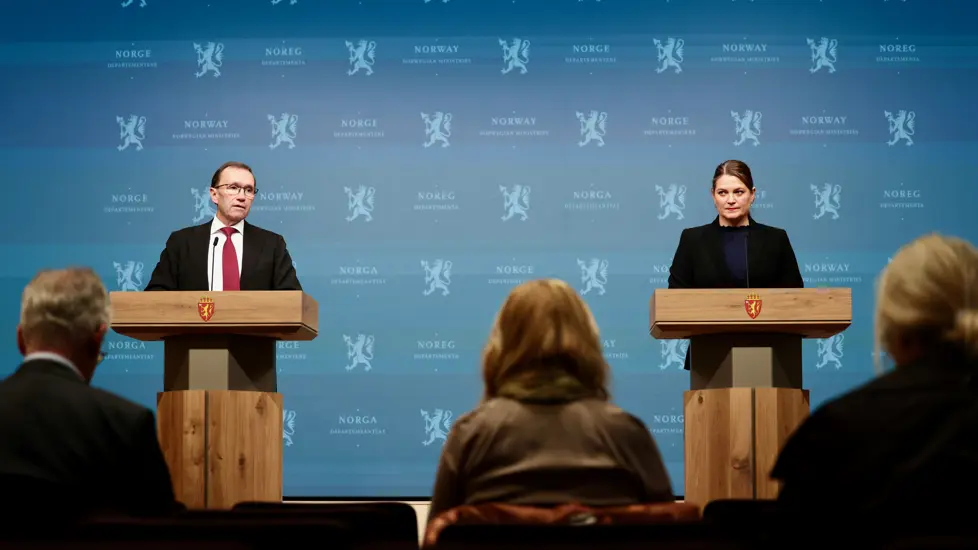 Espen Barth Eide og Cecilie Myrseth står på scenen i presserommet bak hver sin talerstol.