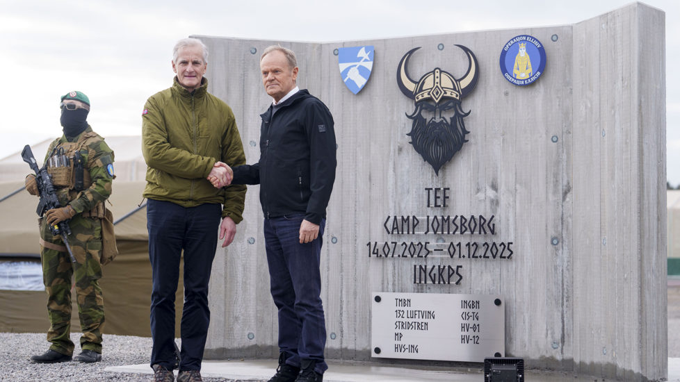 Støre og Tusk tar hverandre i hånda.