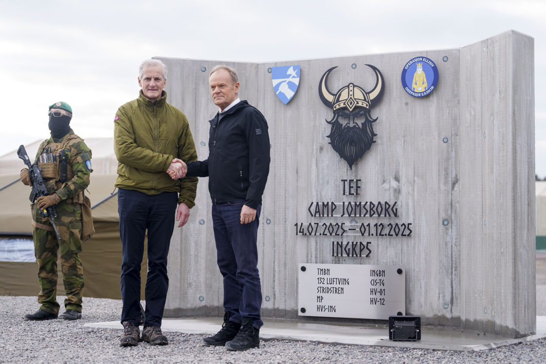 Støre og Tusk tar hverandre i hånda.