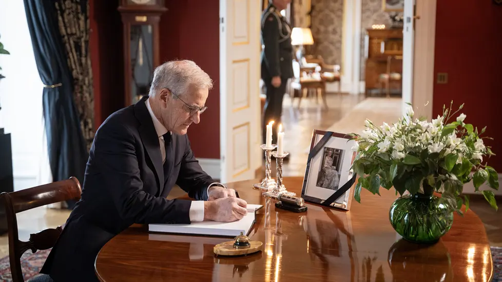 Statsministeren skriver i kondolanseprotokollen på Slottet.