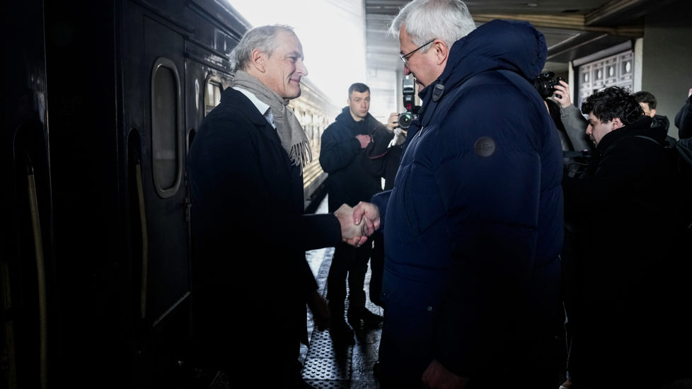 Støre tas imot av Andrii Sybiha på jernbanestasjonen i Kyiv.