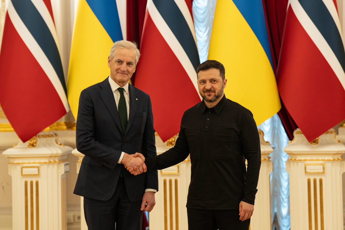 Støre og Zelenskyj foran norsk og ukrainske flagg. Håndtrykk.