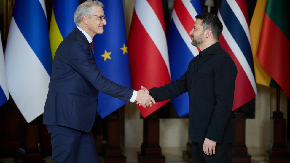 Støre og Zelenskyj hilser foran flagg.