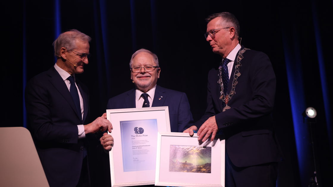 Prime Minister Jonas Gahr Støre, Professor John Smol and principal at the University of Tromsø, Dag Rune Olsen on stage.